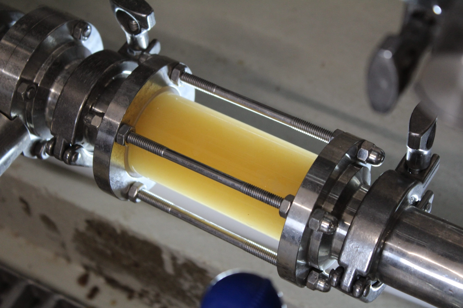 Lessigs Brauwerkstatt GmbH – Das abgebildete Objekt ist ein industrielles Schauglas zur Überwachung von Durchfluss und Qualität einer Flüssigkeit, beispielsweise Bier, während des Brauprozesses.